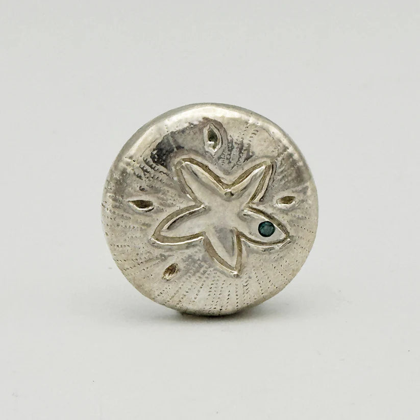 Silver sand dollar charm with starfish design on a gray background